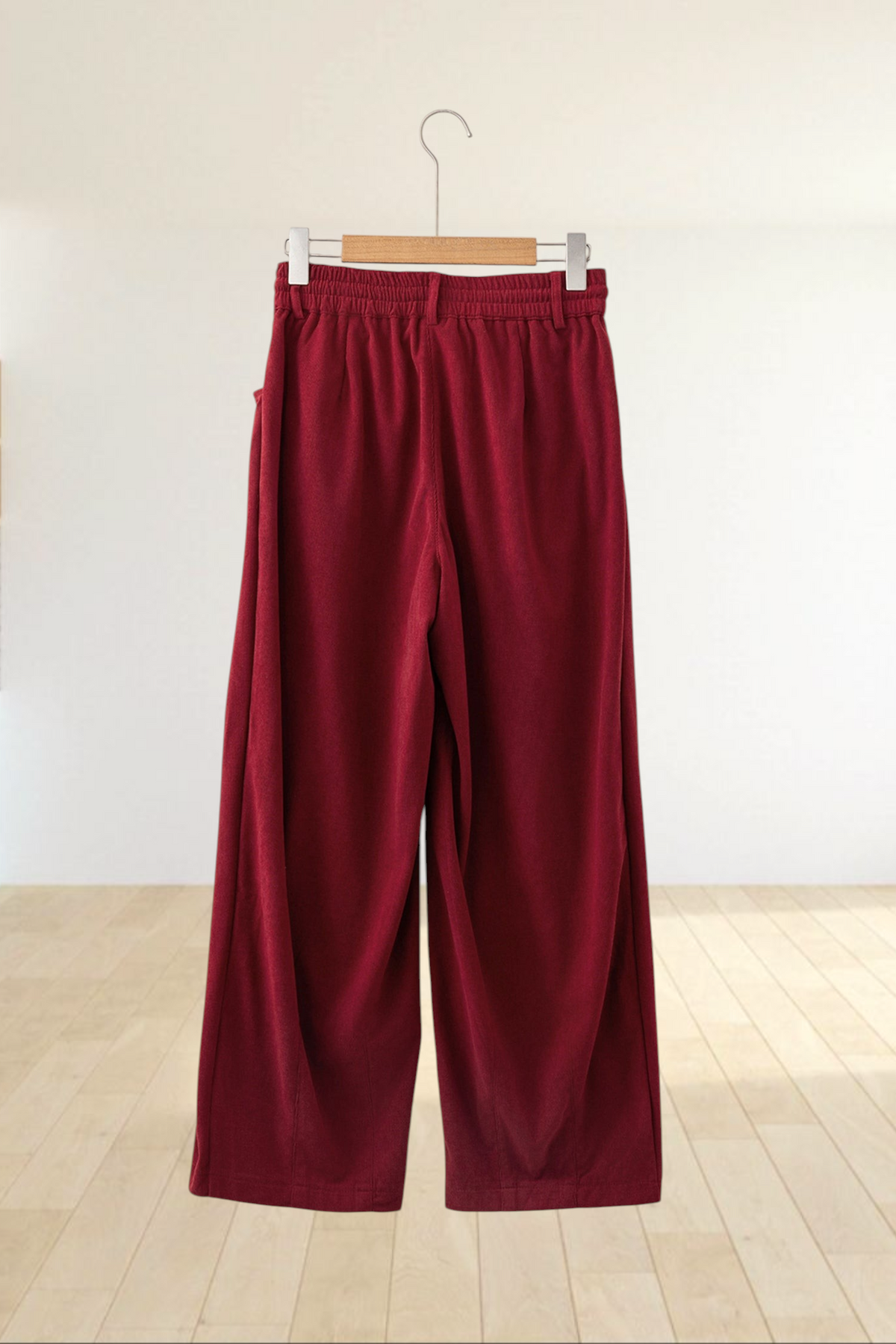 Baya Wear chestnut corduroy trousers with a relaxed wide-leg fit, elastic waistband, and drawstring, back view.