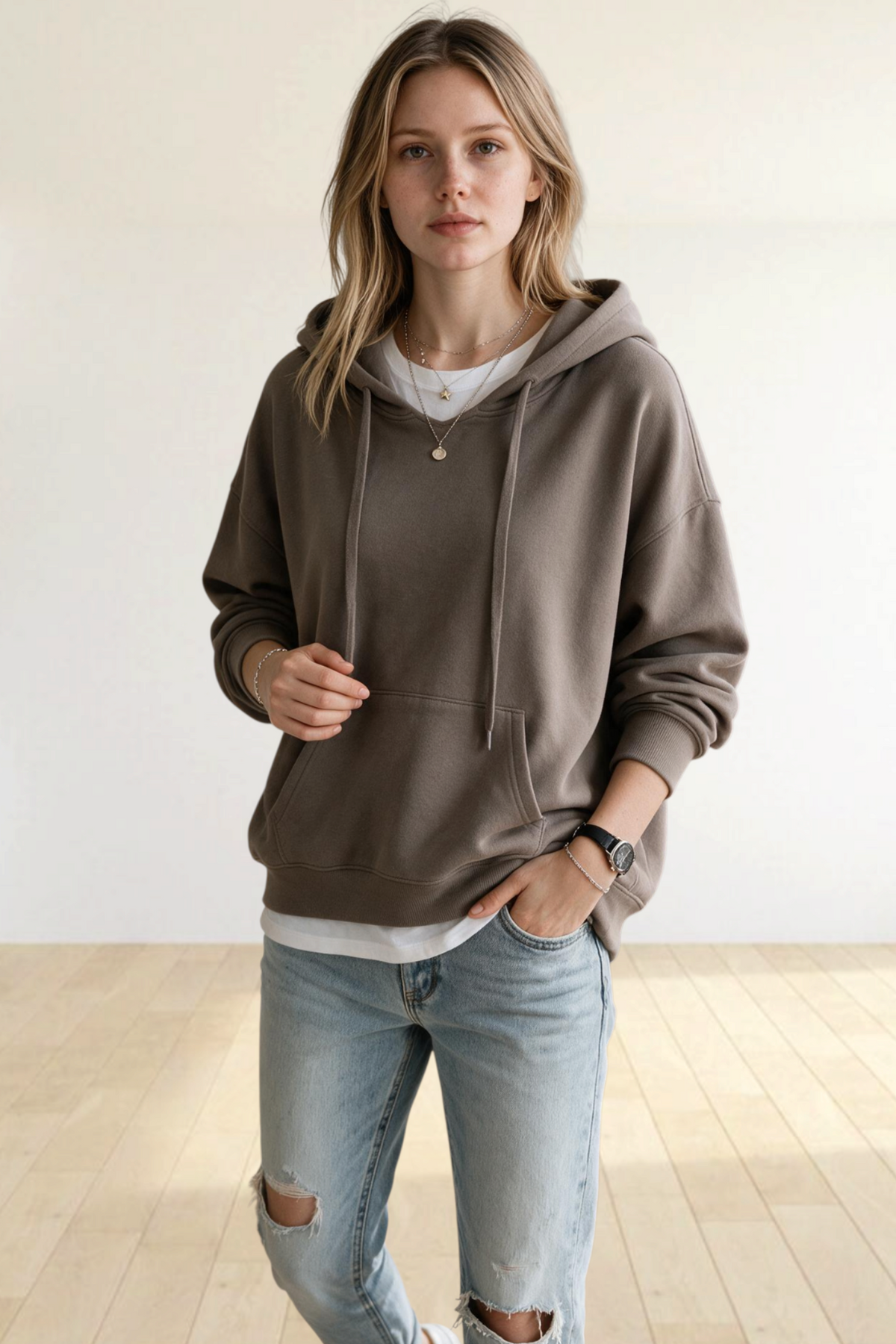 Woman wearing a Baya Wear khaki vintage washed oversized pullover hoodie with a kangaroo pocket and ribbed cuffs.