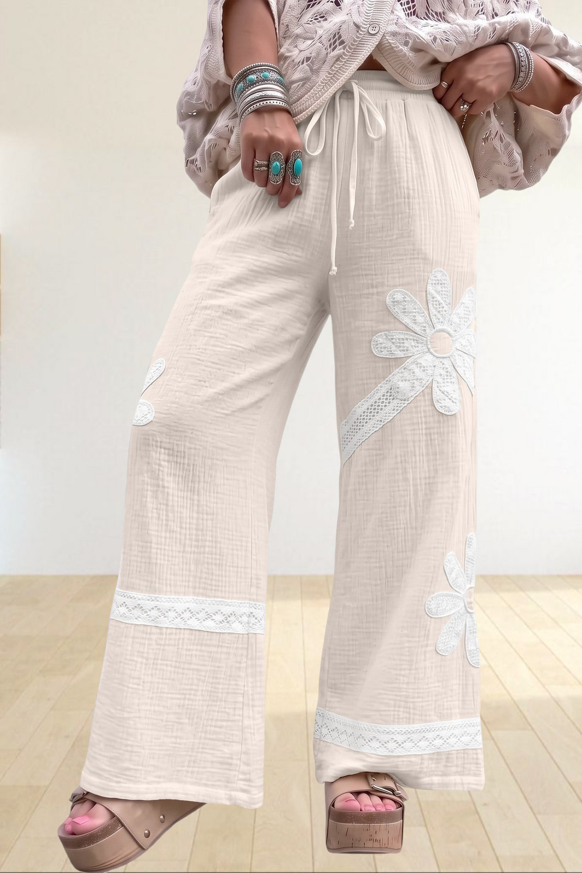 Baya Wear white wide-leg trousers featuring floral lace patchwork, drawstring waist, and soft textured fabric.