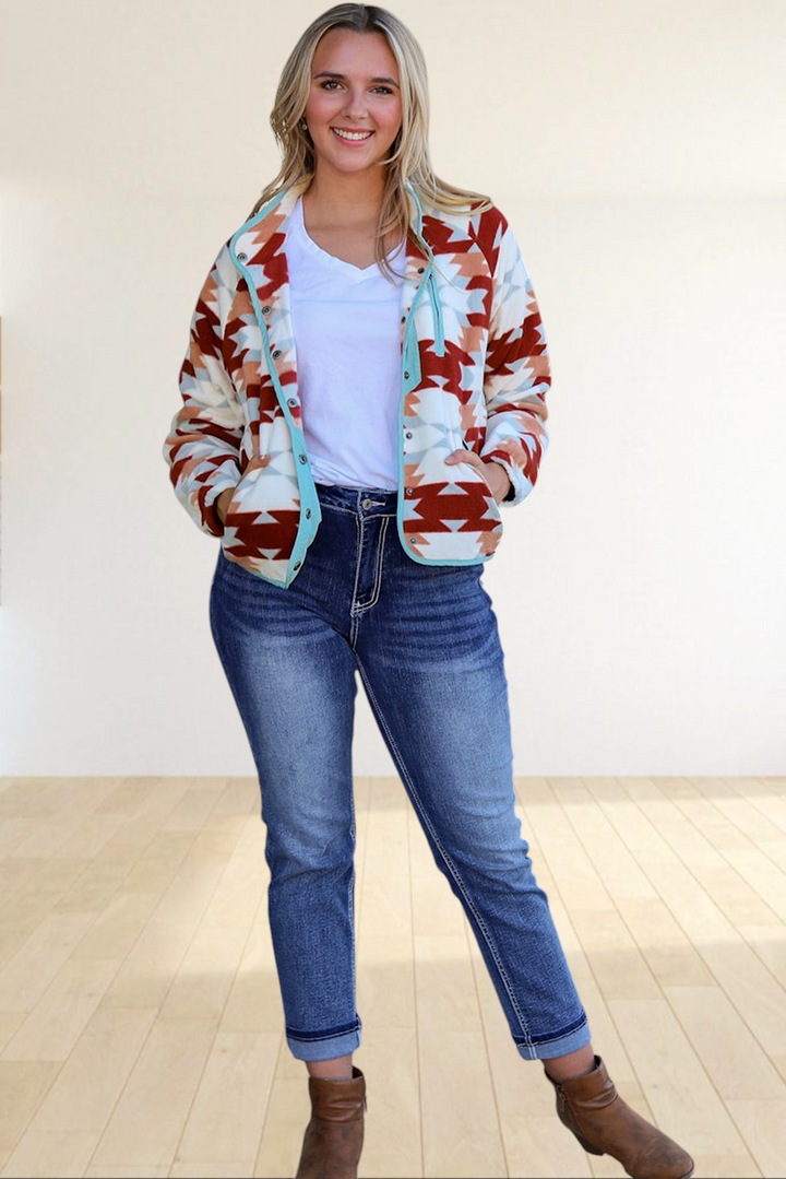 Baya Wear fleece snap jacket featuring a fiery red and cream Aztec pattern with light blue trim on a smiling model.