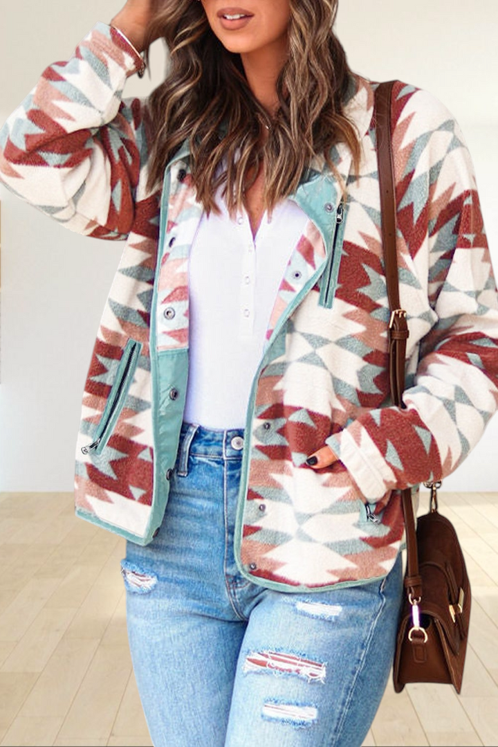 Baya Wear fiery red and cream Aztec print fleece snap jacket with light blue trim worn by a woman with denim jeans