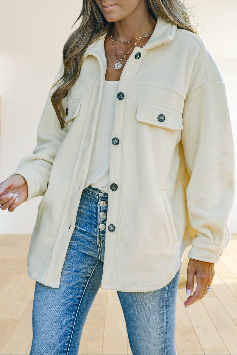 Baya Wear beige fleece shacket with a turn-down collar, button-front closure, and chest pockets worn over blue jeans.