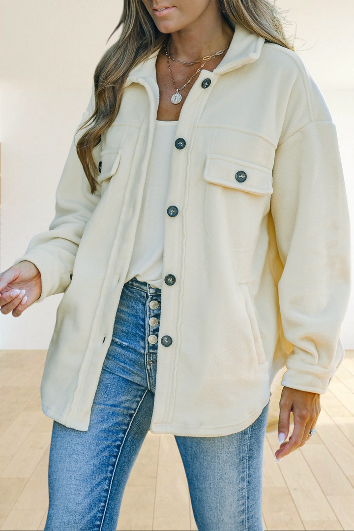 Baya Wear beige fleece shacket with a turn-down collar, button-front closure, and chest pockets worn over blue jeans.