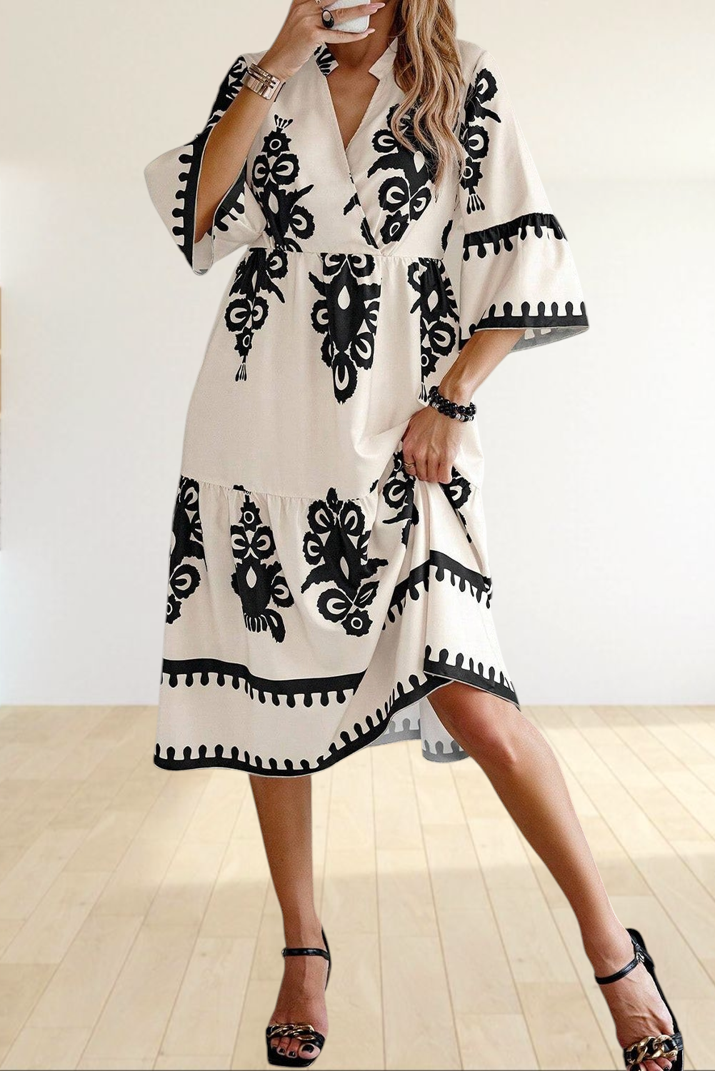 Baya Wear beige midi dress with black geometric print, V-neckline, tiered skirt, and 3/4 sleeves on a model
