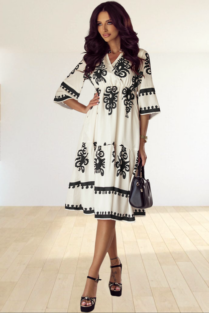 Baya Wear beige midi dress with black geometric print, V-neck, 3/4 sleeves, and tiered skirt worn by a model.