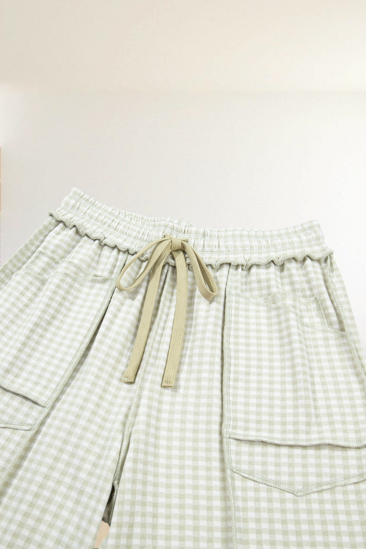 Baya Wear wide leg lounge pants in beige gingham plaid with an elastic drawstring waist and contrast trim pockets.