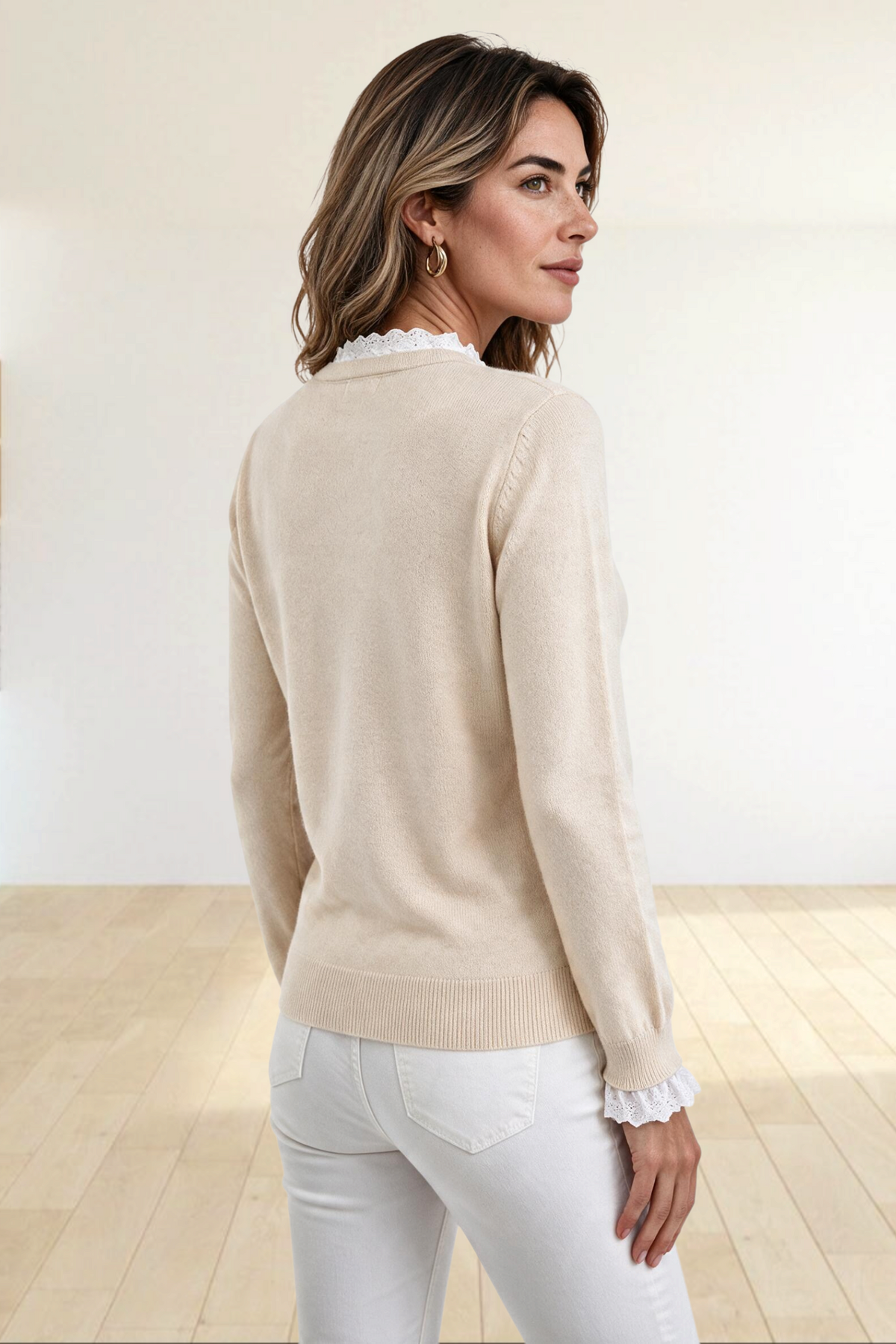 Baya Wear beige long sleeve crew neck knit sweater with delicate lace trim at the collar and cuffs on a woman