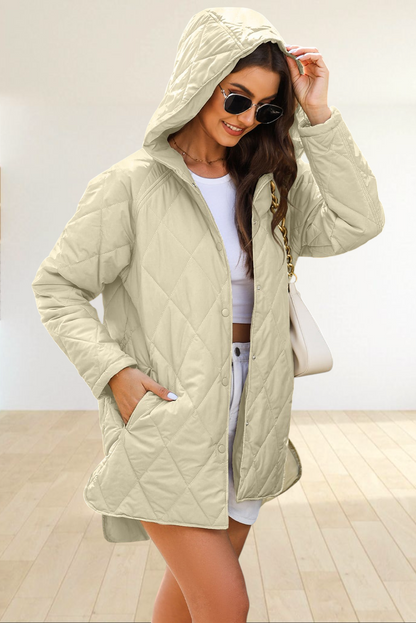 Baya Wear beige diamond-quilted longline hooded jacket with snap buttons and side pockets worn by a woman outdoors.