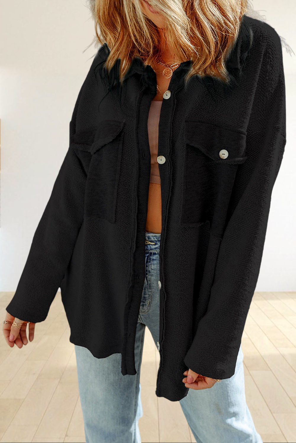 Baya Wear black textured shacket with button-down front, chest flap pockets, and raw-edge details on a model.