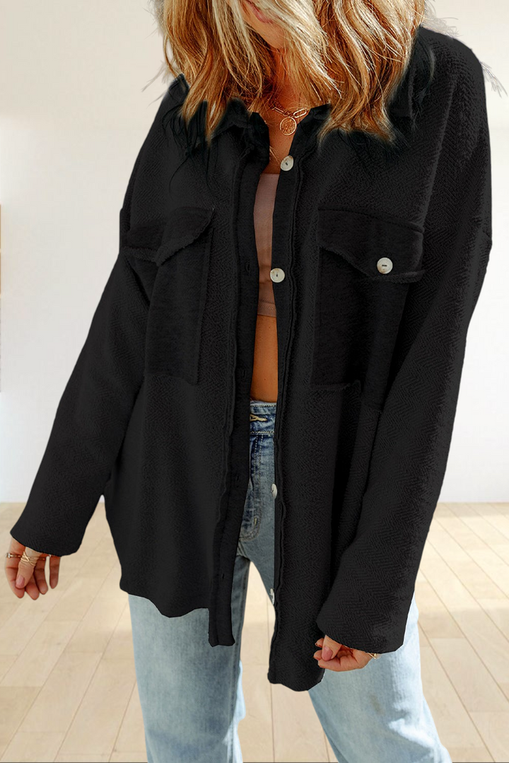 Baya Wear black textured shacket with button-down front, chest flap pockets, and raw-edge details on a model.
