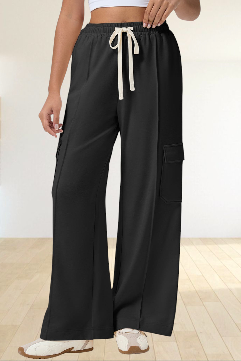 Baya Wear black high-waisted wide-leg cargo sweatpants with side patch pockets and a cream drawstring waist.