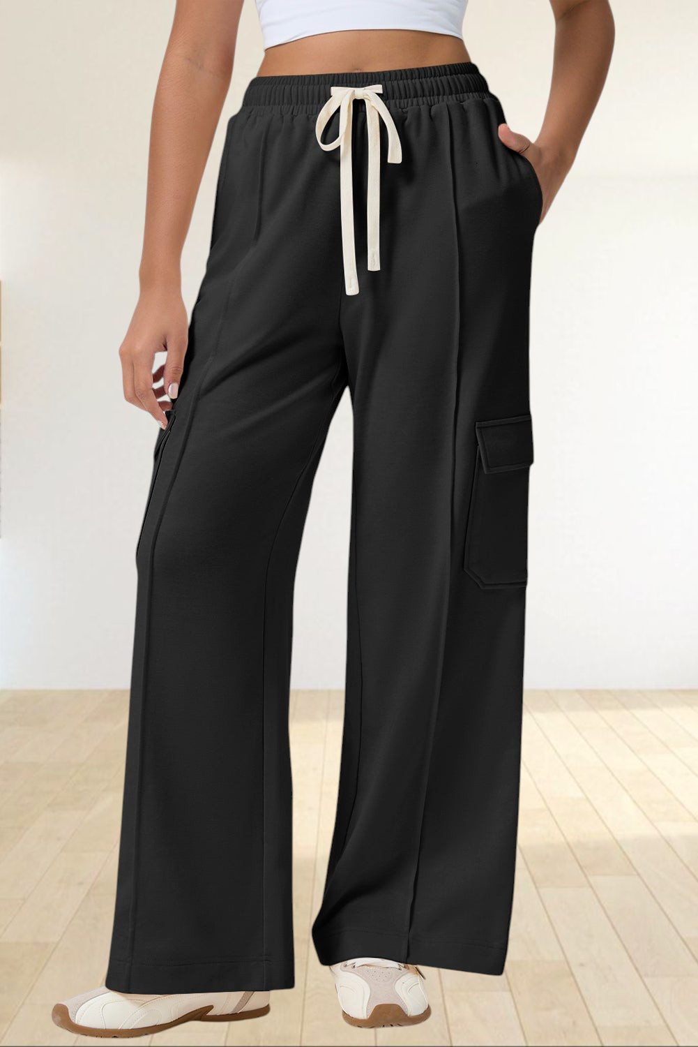 Baya Wear black high-waisted wide-leg cargo sweatpants with side patch pockets and a cream drawstring waist.