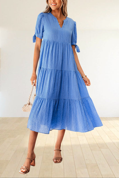 Baya Wear blue textured gingham tiered midi dress with V-neck, short sleeves, and bow-tie details on a model