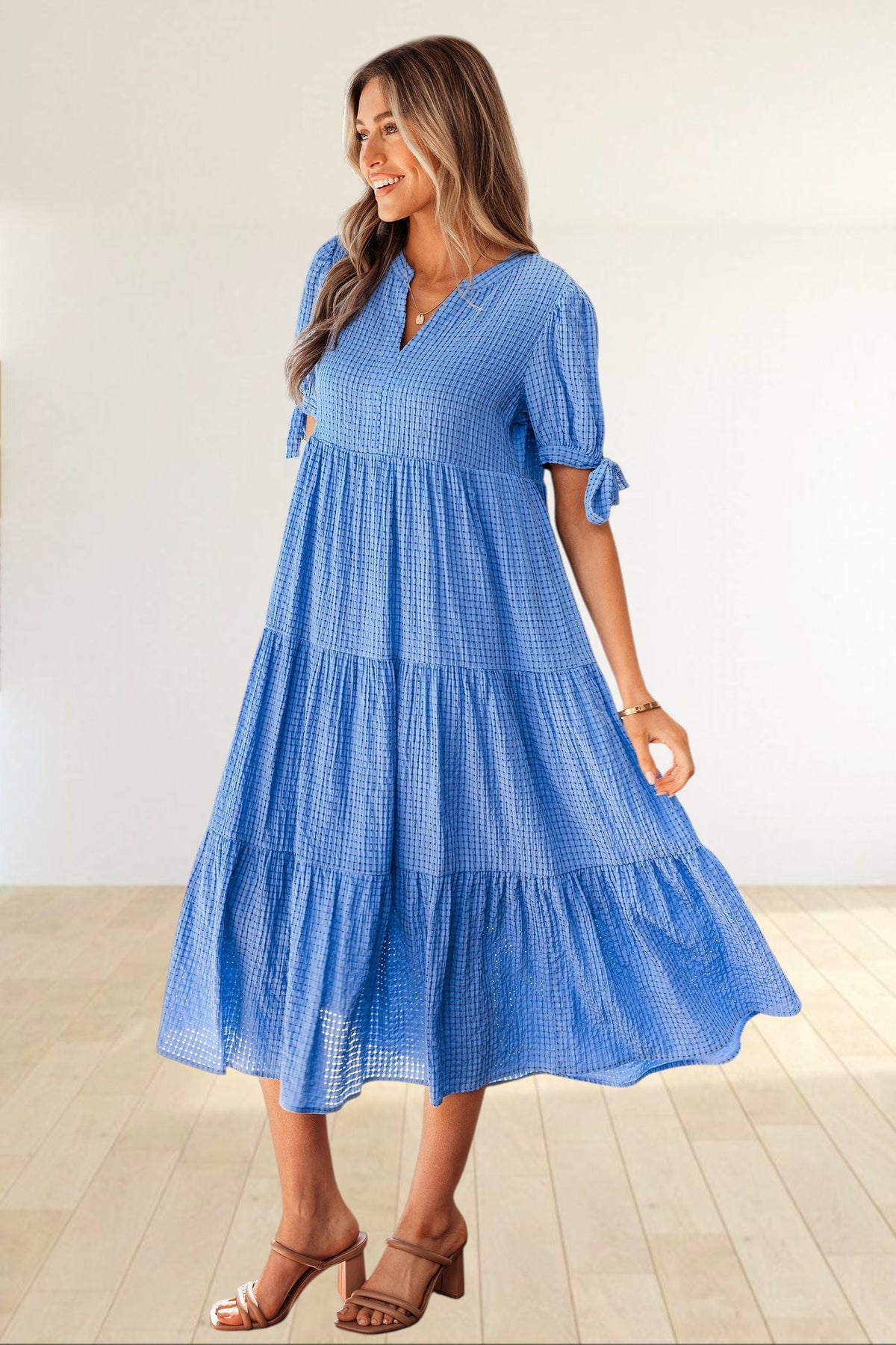 Baya Wear blue textured gingham tiered midi dress with V-neck, short sleeves, and bow-tie details on a model.