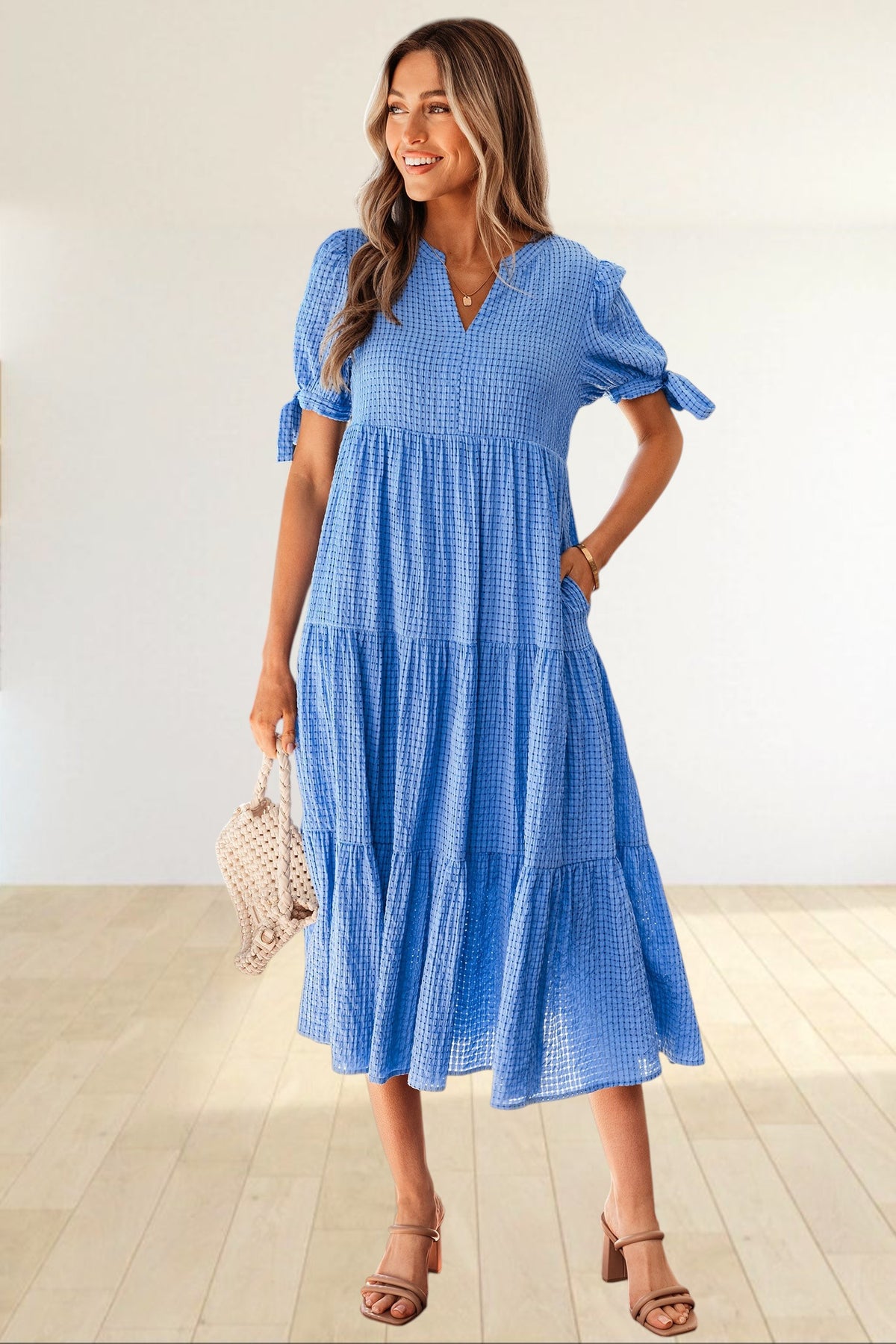 Baya Wear blue textured gingham tiered midi dress with V-neckline, short sleeves with bow ties, and side pockets.