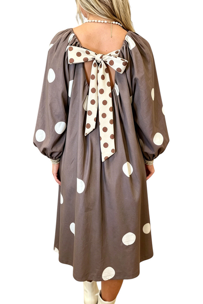 Baya Wear brown midi dress with white polka dots, long sleeves, and a large contrast bow detail on the open back.