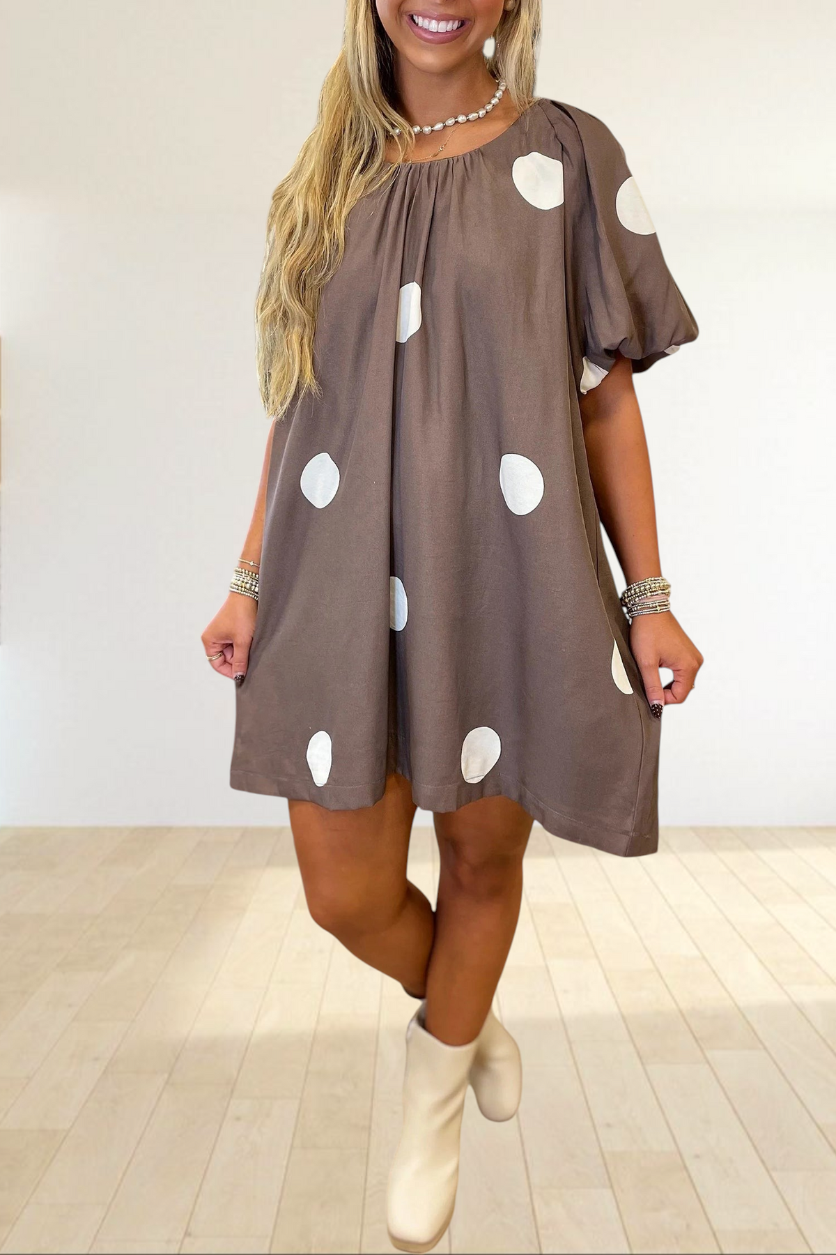 Baya Wear brown mini dress with white polka dots, puff sleeves, and a gathered neckline worn by a blonde woman