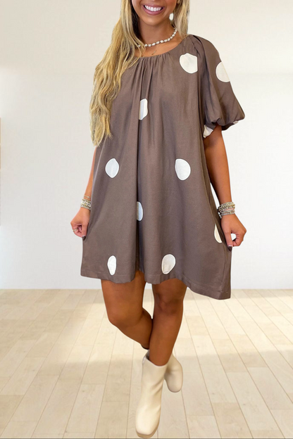 Baya Wear brown mini dress with white polka dots, puff sleeves, and a gathered neckline worn by a blonde woman