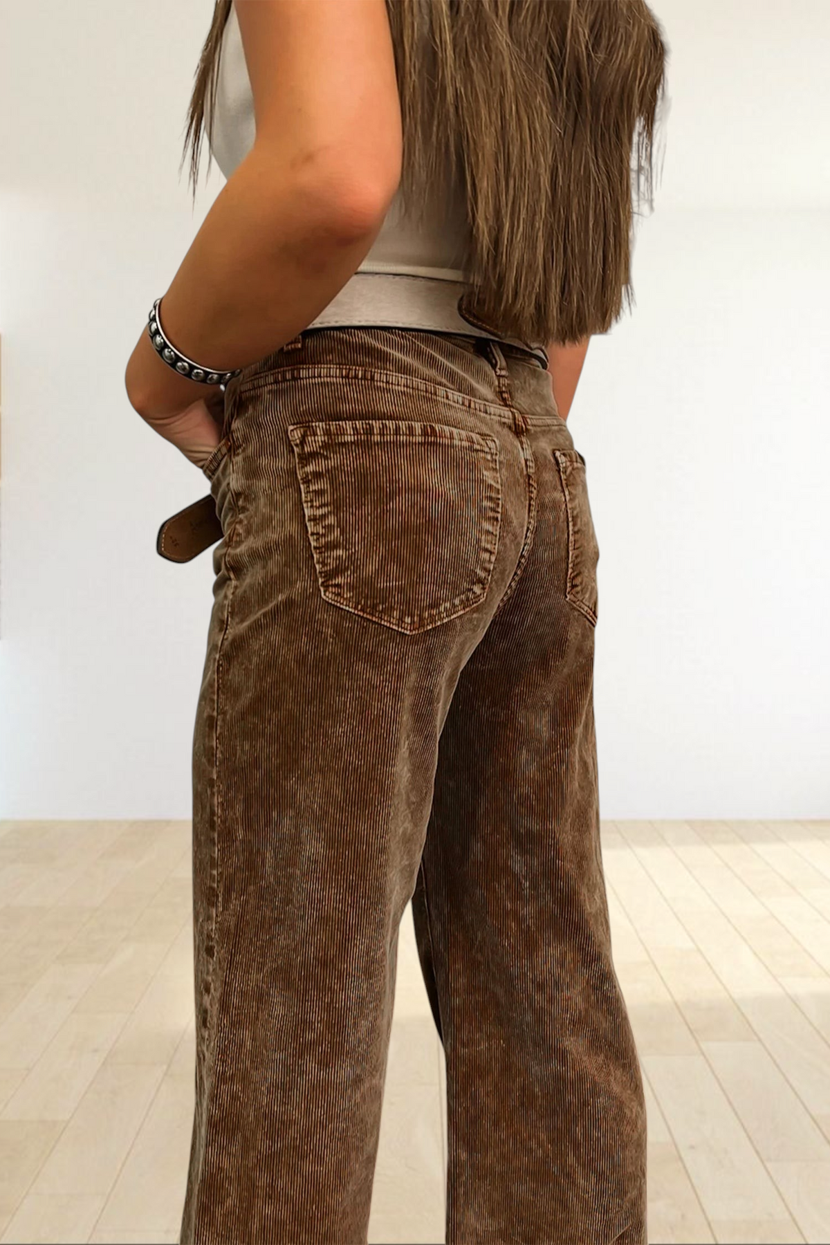 Baya Wear camel corduroy wide leg pants with back pockets, styled with a white top against western-themed wallpaper.
