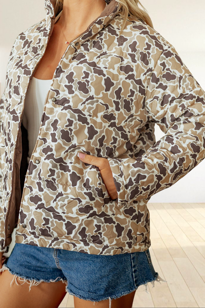 Baya Wear multicolour camouflage quilted puffer jacket with snap buttons and side pockets worn with denim shorts.