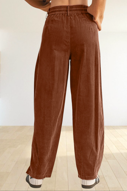 Baya Wear chestnut brown corduroy trousers with a relaxed wide-leg fit and elastic waistband, back view.