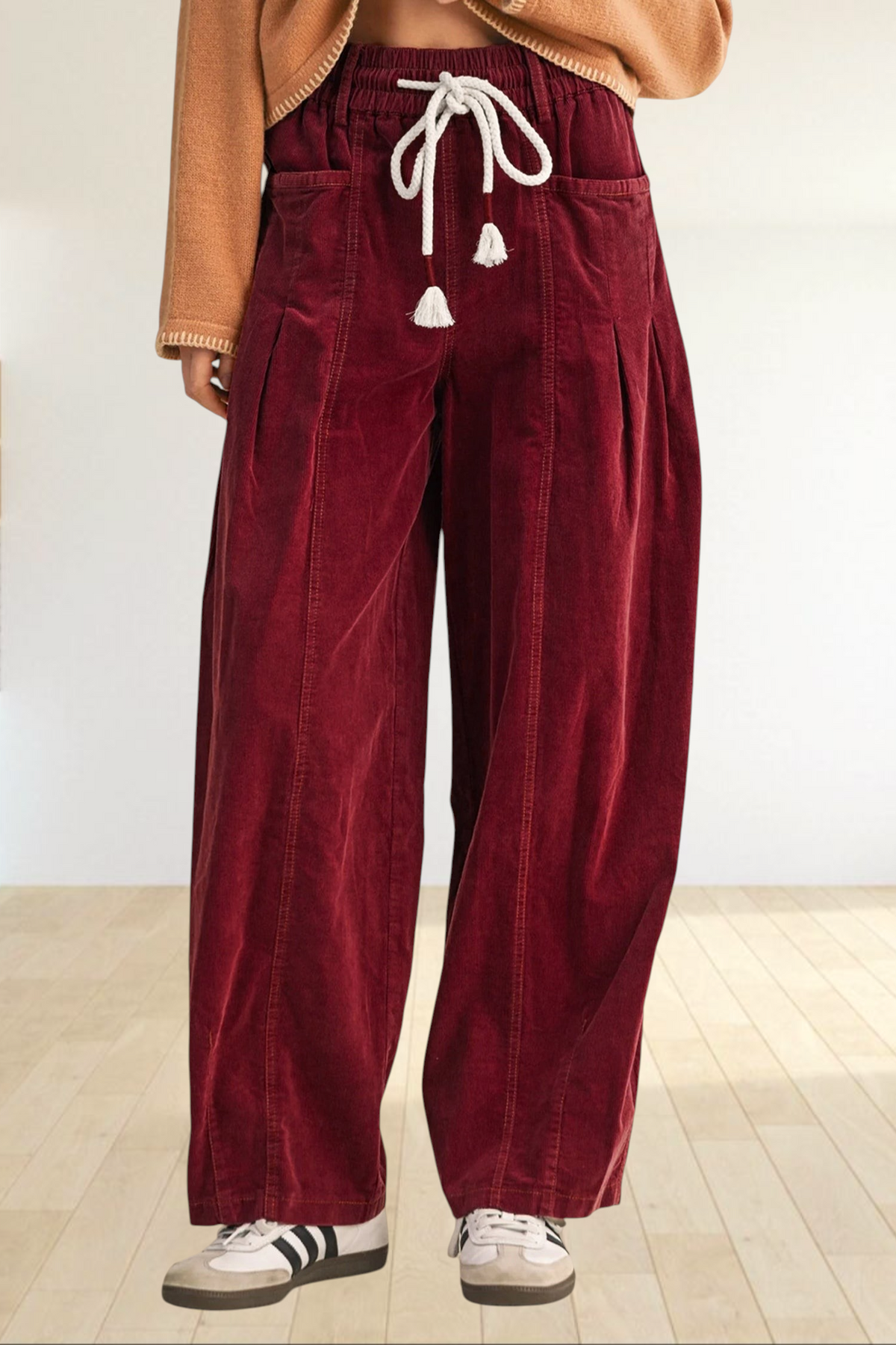 Baya Wear chestnut corduroy wide-leg trousers with an elastic drawstring waist and tassel details on a model.