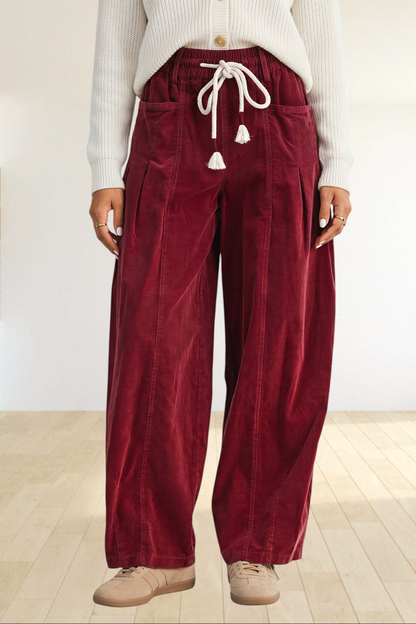 Baya Wear chestnut corduroy wide-leg trousers with an elastic drawstring waist and tassel details.