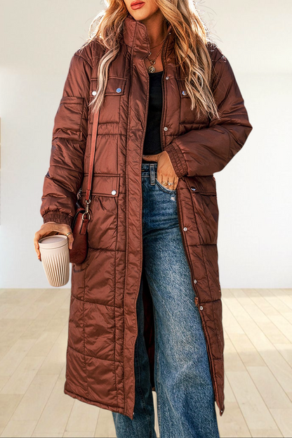 Baya Wear coffee brown long quilted puffer jacket with stand neck, zip closure, and flap pockets worn outdoors.