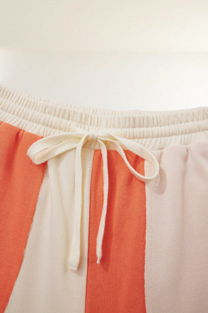 Baya Wear color block lounge pants with an elastic drawstring waistband and raw-edge seams in orange and cream