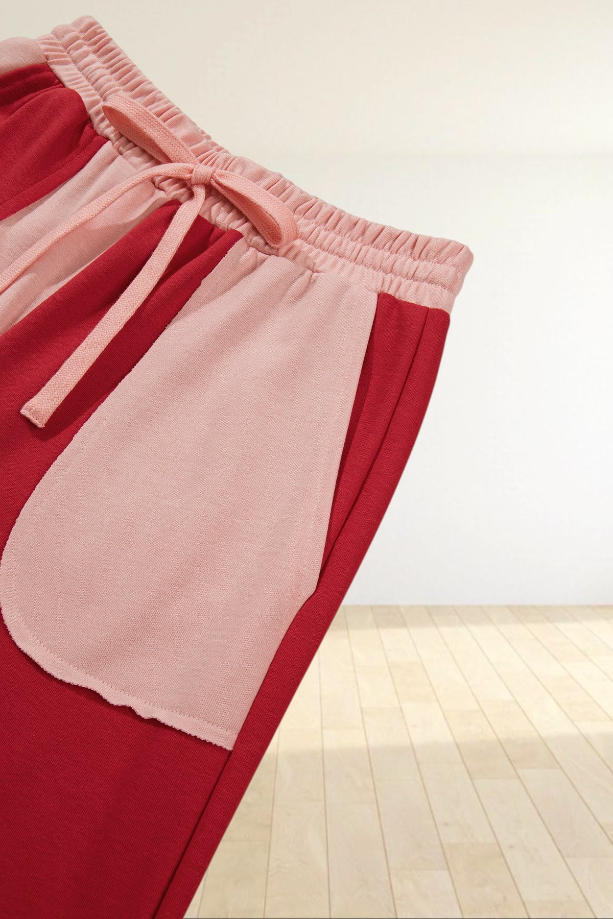 Baya Wear color block lounge pants in red and soft pink with an elastic drawstring waist and large patch pocket.