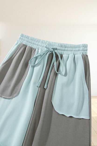 Baya Wear color block wide-leg lounge pants in light blue and grey with an elastic drawstring waist and patch pockets.