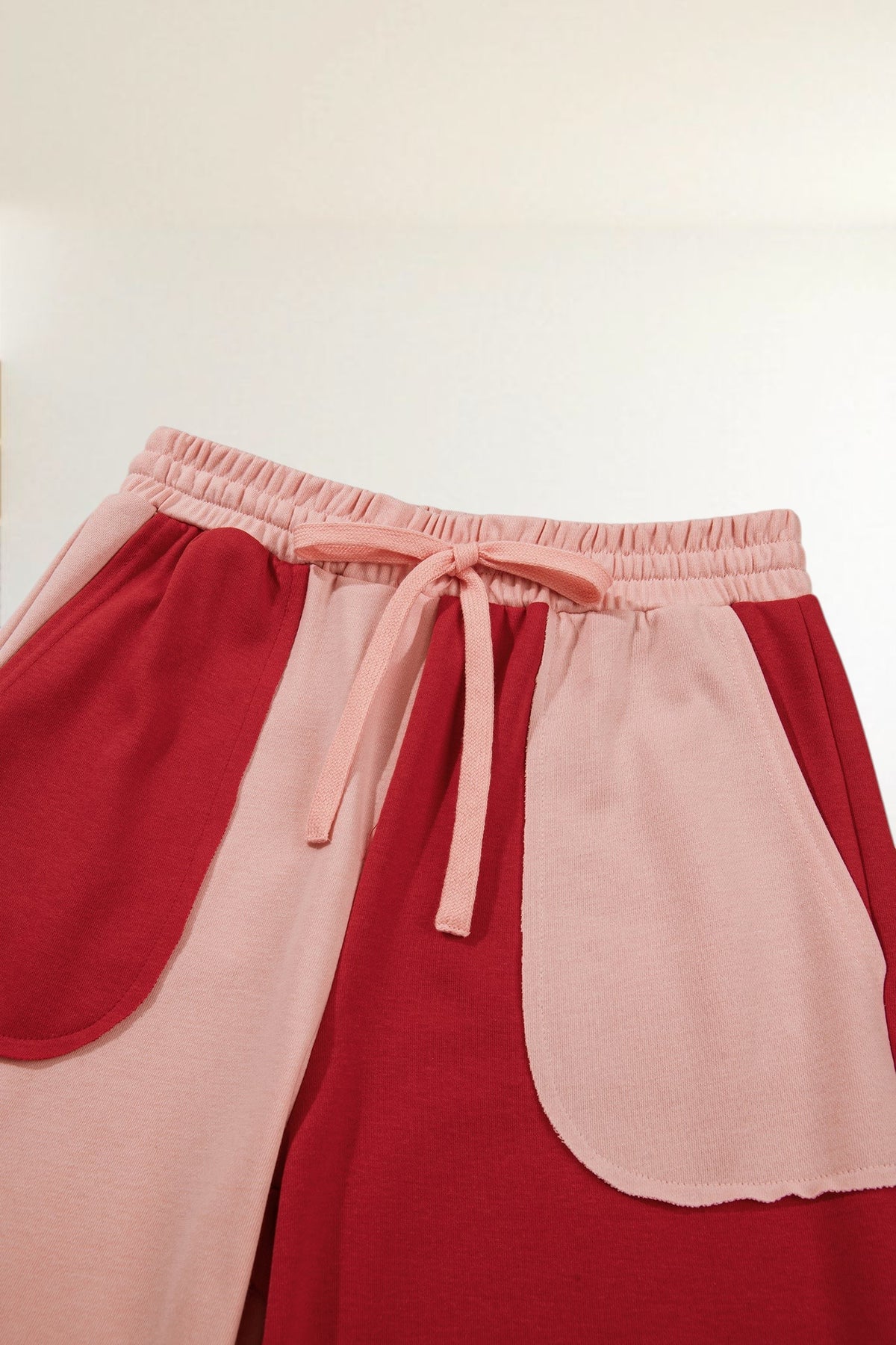 Baya Wear color block wide leg lounge pants in pink and red with an elastic drawstring waistband and patch pockets
