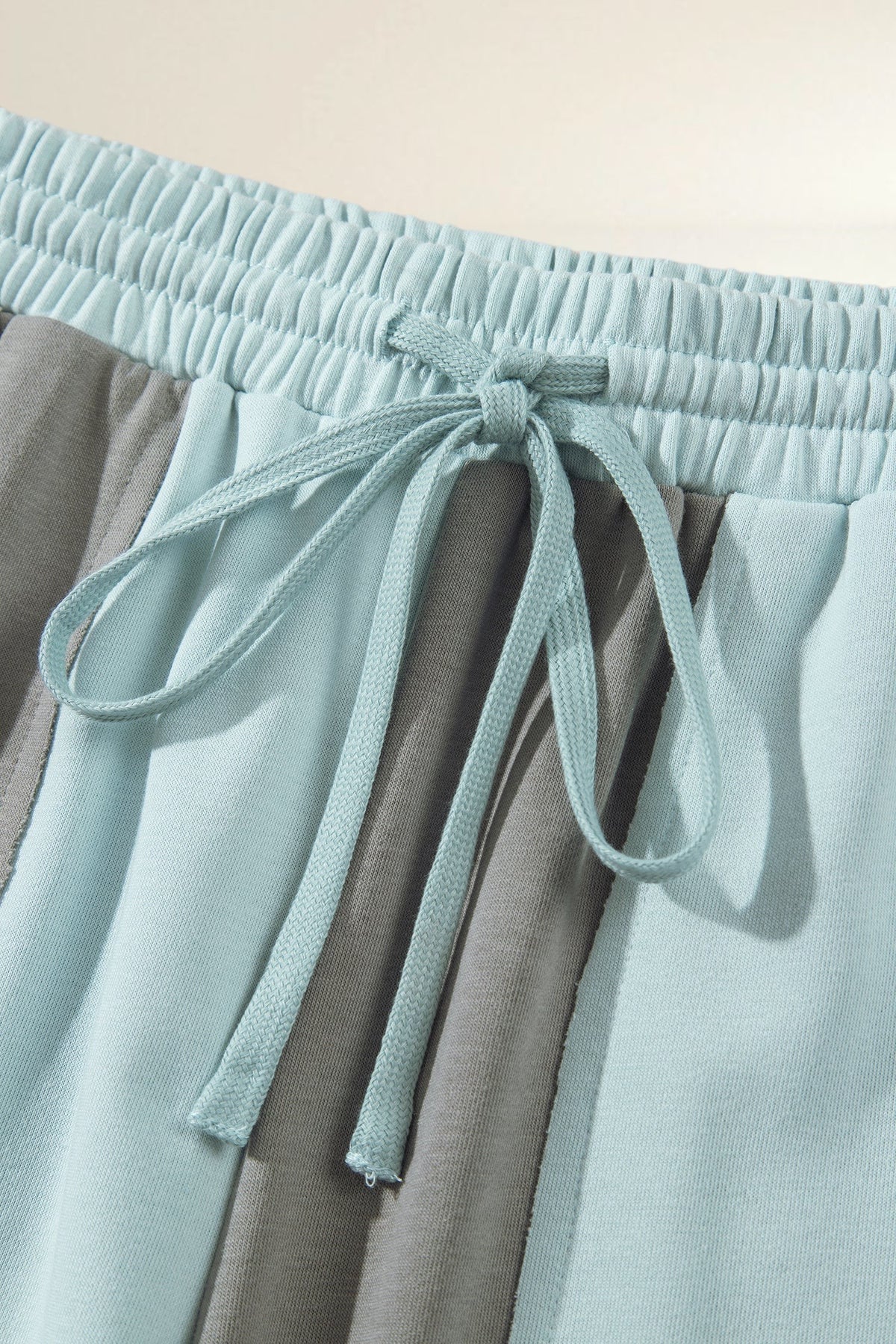 Baya Wear color block lounge pants in light blue and grey with an elastic drawstring waistband and raw-edge seams.
