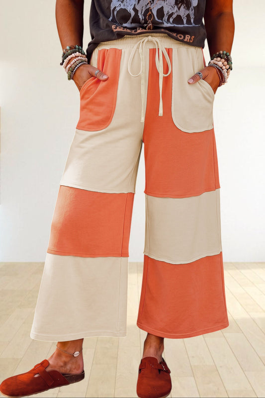 Baya Wear color block wide-leg lounge pants in cream and orange with raw-edge seams, drawstring waist, and pockets.