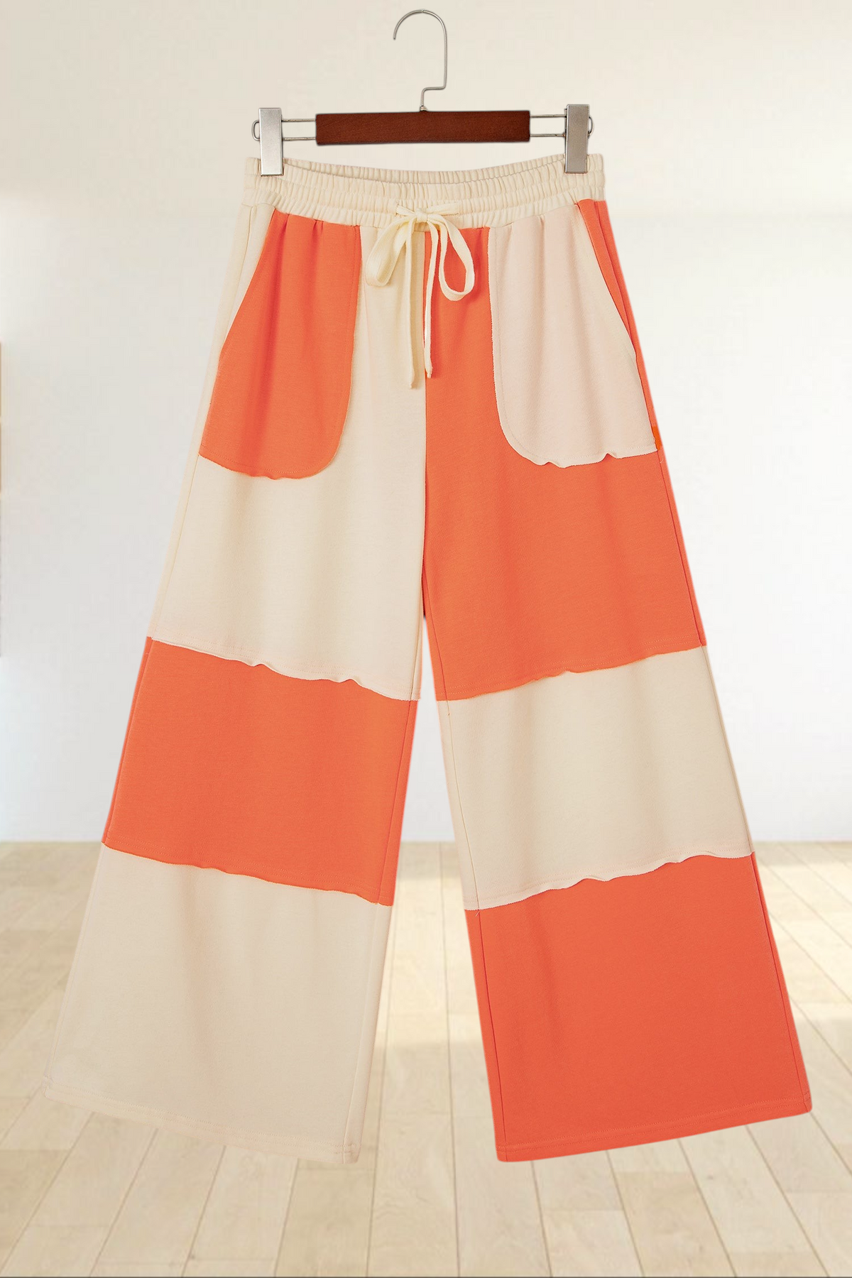 Baya Wear color block wide-leg lounge pants in orange and cream with raw-edge seams and a drawstring waist.