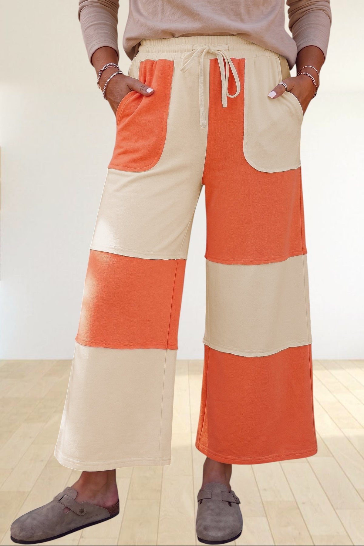Baya Wear wide-leg lounge pants in orange and cream colorblock patchwork with raw-edge seams and drawstring waist.