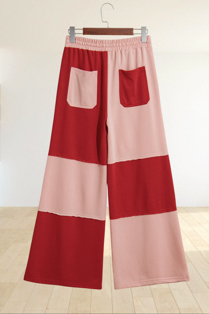 Baya Wear color block wide-leg lounge pants in red and pink with raw-edge seams, drawstring waist, and back pockets.