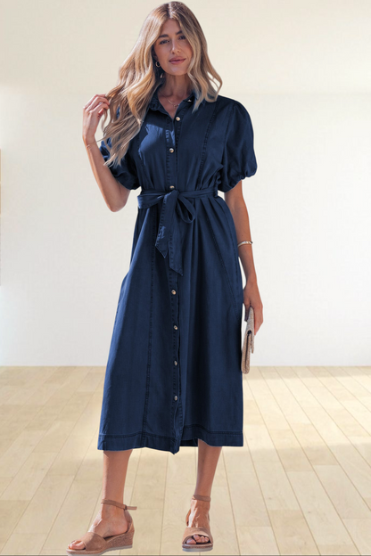 Baya Wear dark blue denim midi dress with puff sleeves, collared neckline, and tie-waist belt worn by a woman.