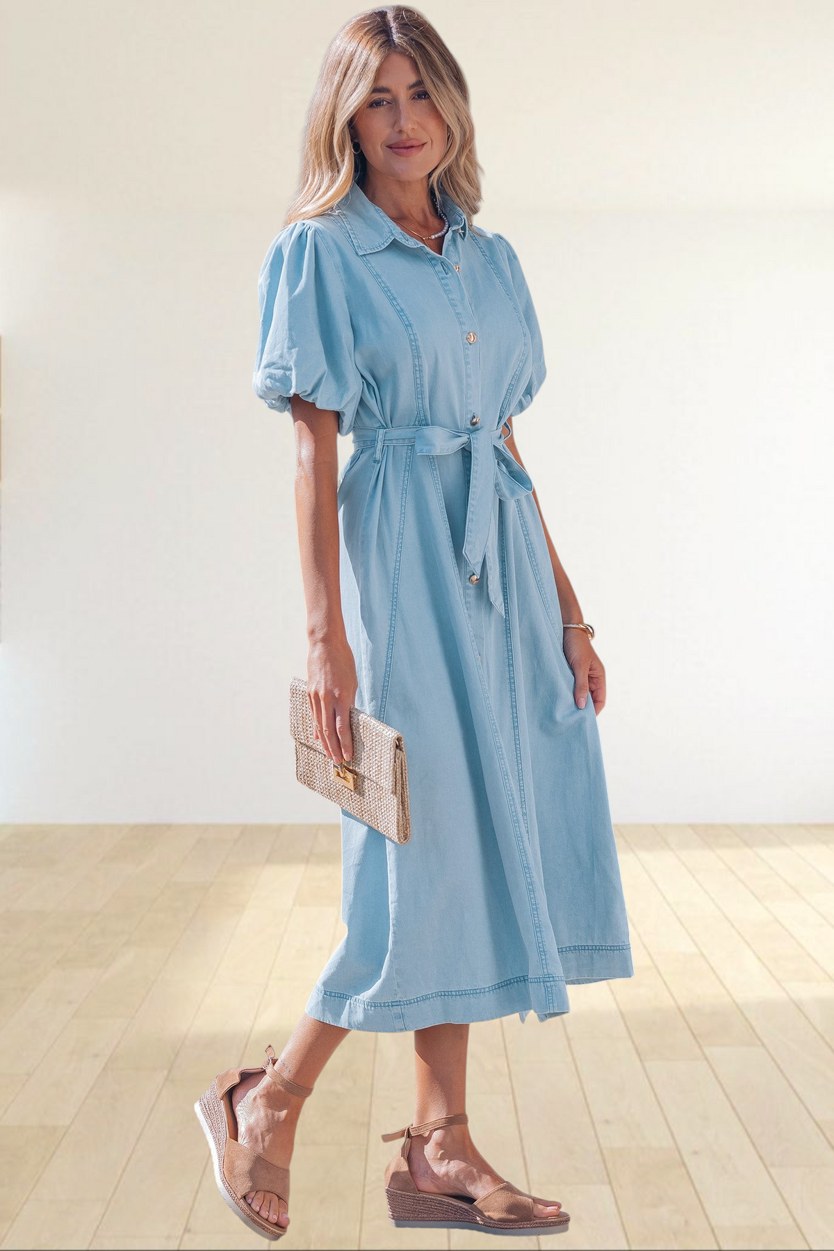 Baya Wear light blue denim midi dress with puff sleeves, button front, and tie-waist belt worn by a woman outdoors.