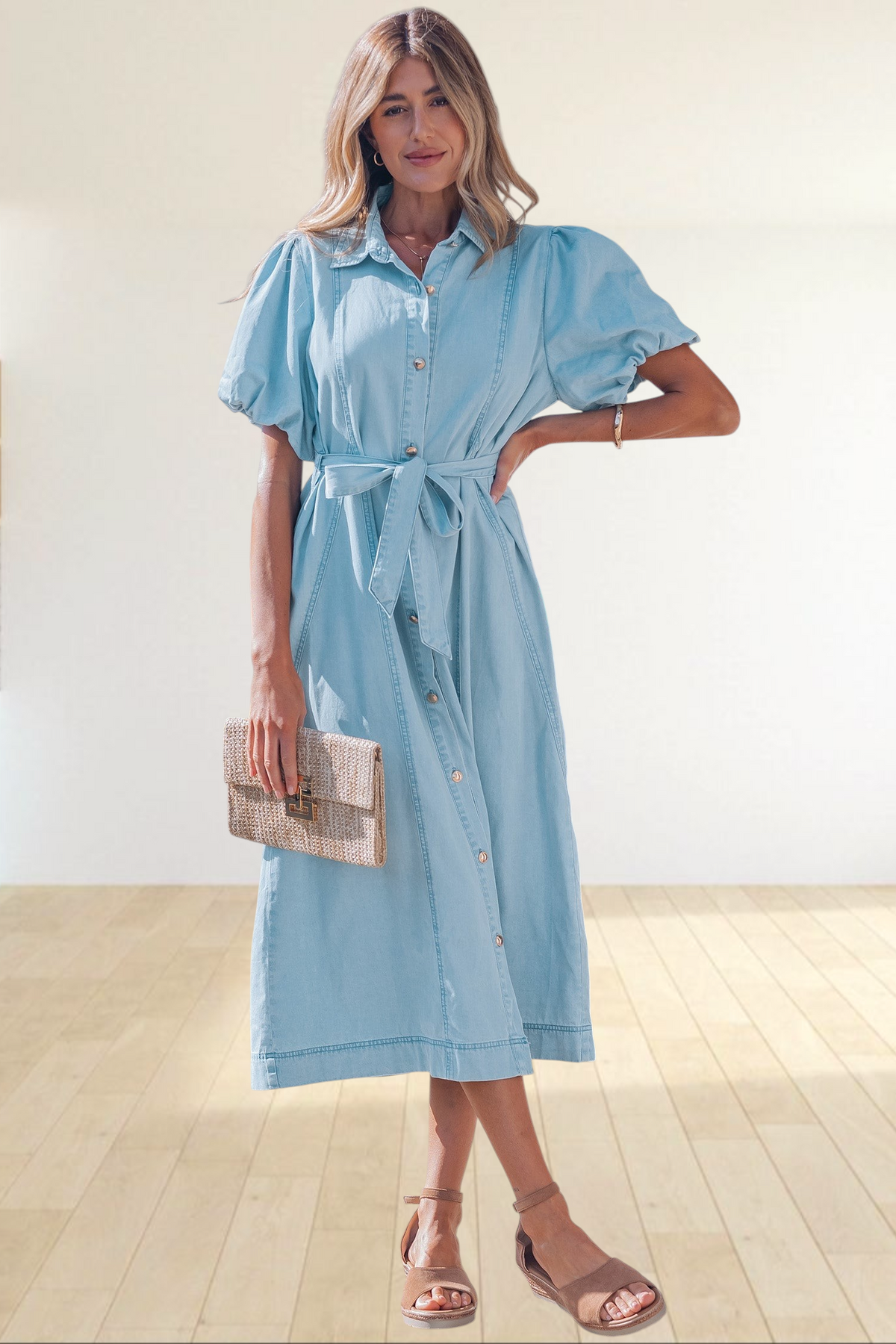 Baya Wear light blue denim midi dress with puff sleeves, button-down front, and tie-waist belt worn by a woman.