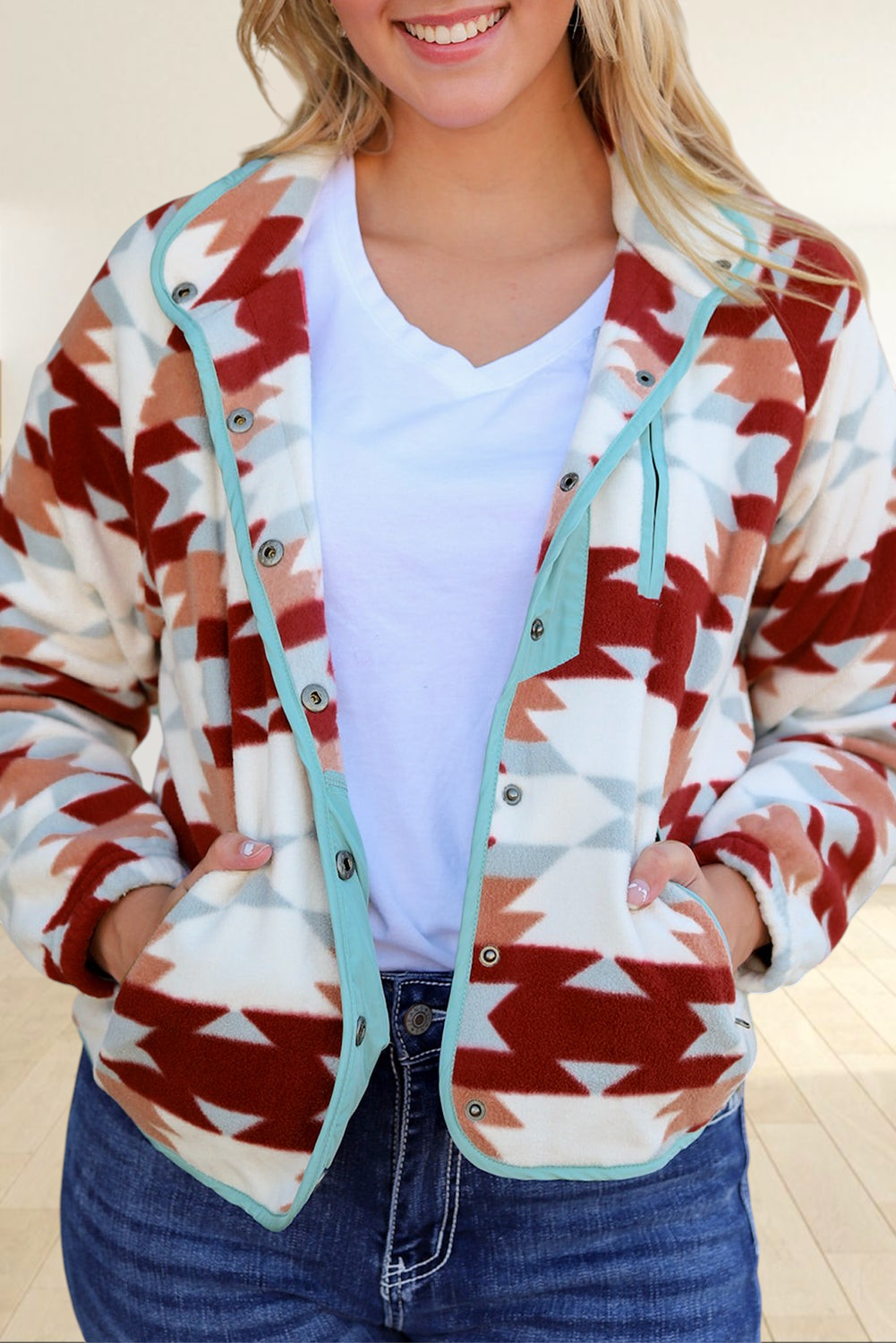 Baya Wear geometric patterned fleece snap jacket in fiery red, cream, and blue with a button-front and pockets.