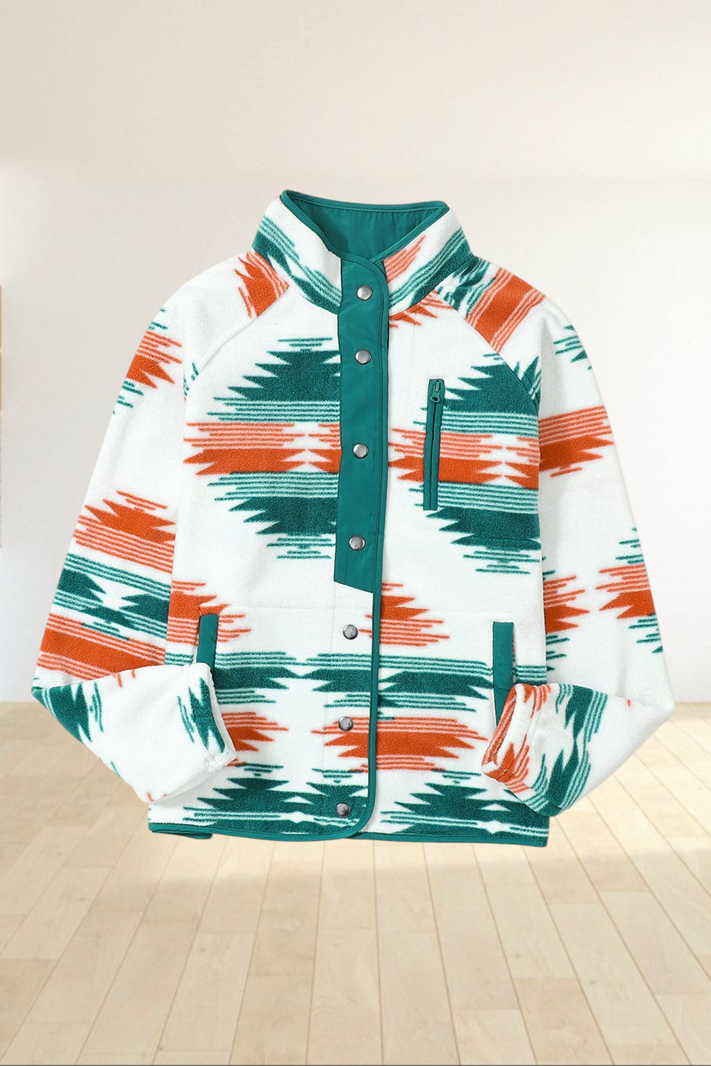 Baya Wear fleece jacket featuring a geometric pattern in orange and green on cream with snap buttons and zip pockets.