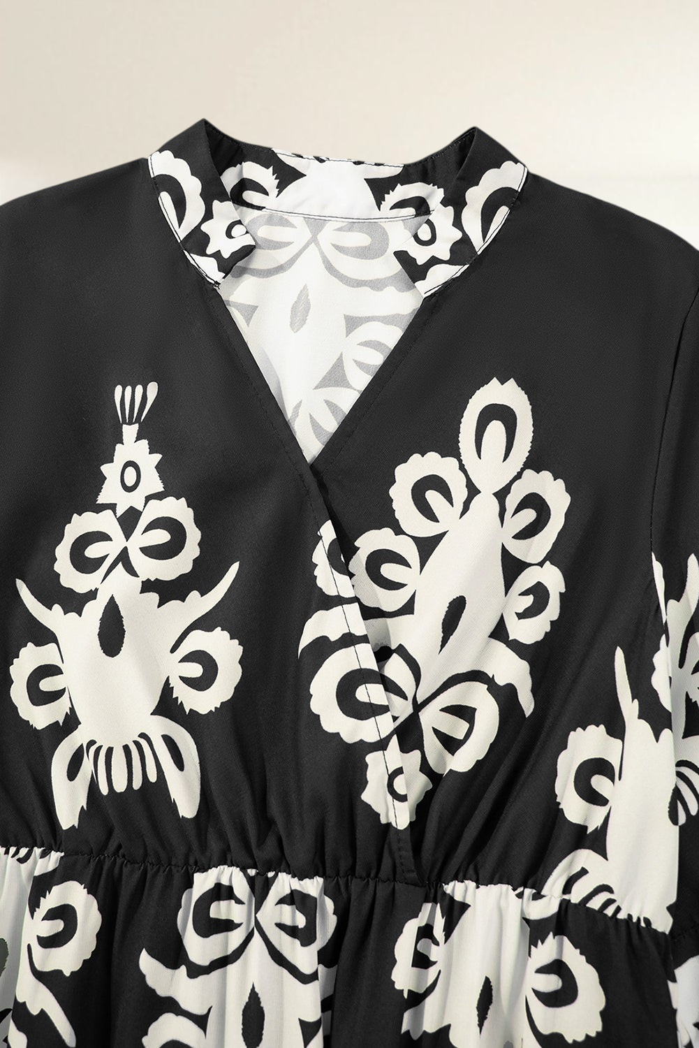 Baya Wear black and white geometric print V-neck midi dress with a cinched waist and elegant collar detail.