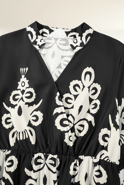 Baya Wear black and white geometric print V-neck midi dress with a cinched waist and elegant collar detail.