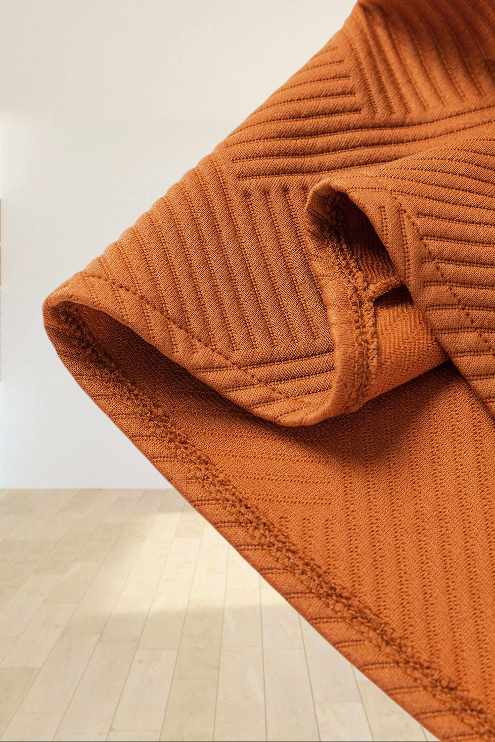 Close-up of Baya Wear gold flame textured duster coat fabric showing geometric pattern and soft material detail