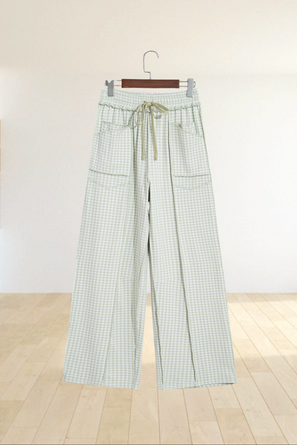 Baya Wear wide leg lounge pants in light green gingham check with a drawstring waist, pockets, and ruffled trim.