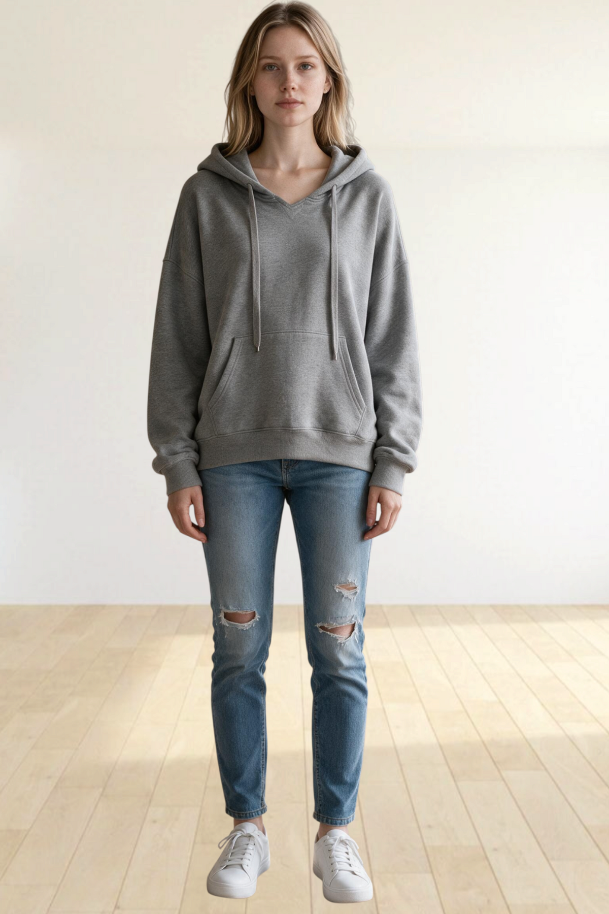 Baya Wear grey oversized pullover hoodie with kangaroo pocket and ribbed cuffs worn by a woman with distressed jeans