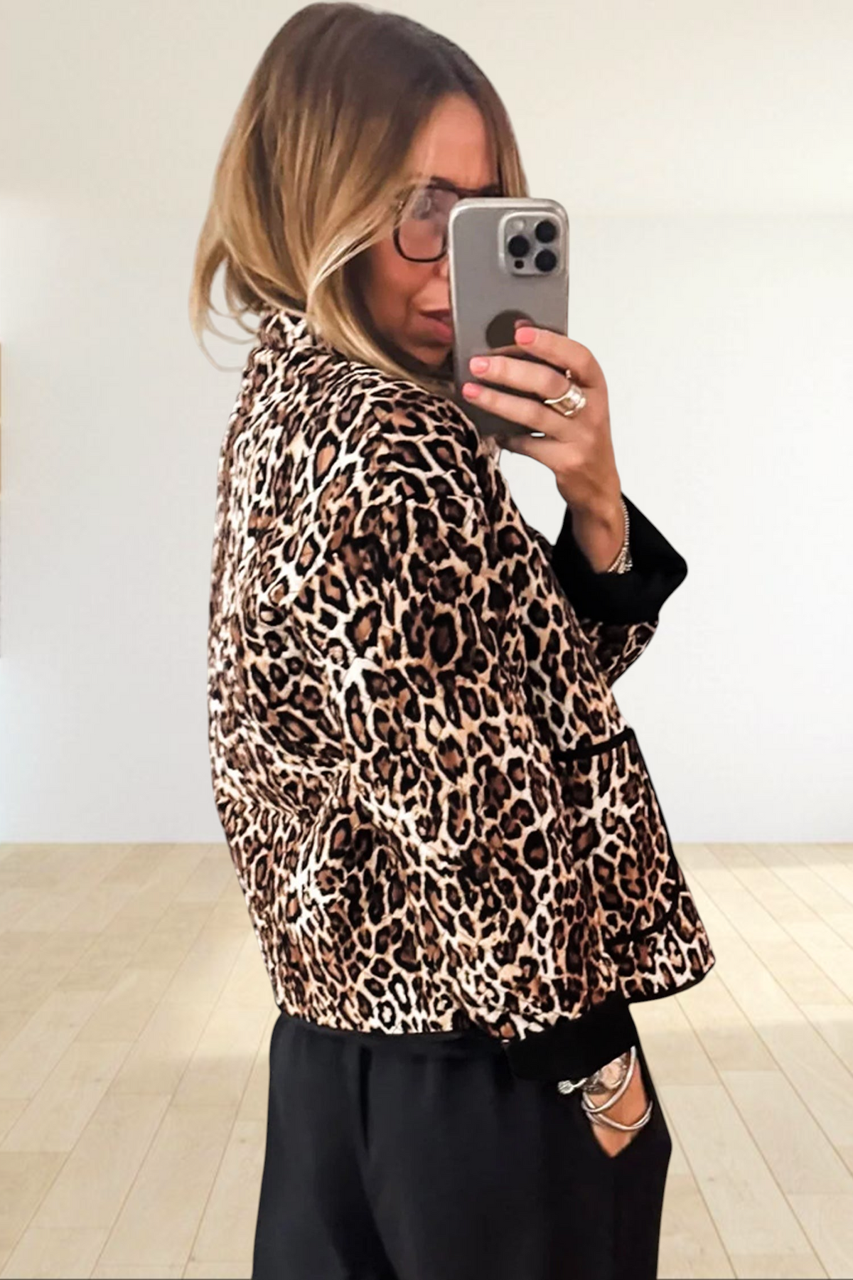 Baya Wear quilted leopard print jacket with black trim and front pockets worn by a woman taking a mirror selfie
