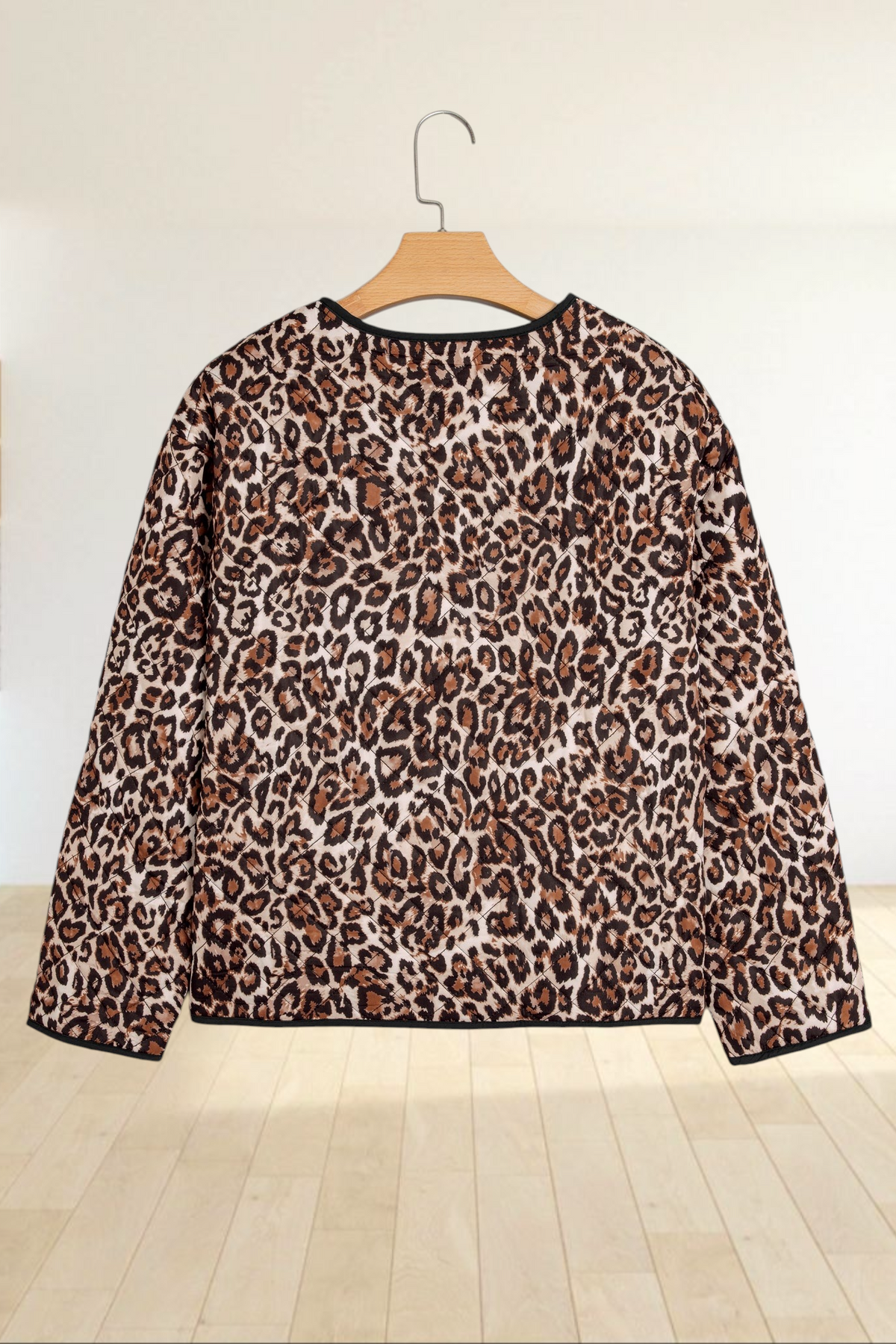 Baya Wear brown leopard print quilted jacket with black trim, shown from the back on a wooden hanger.
