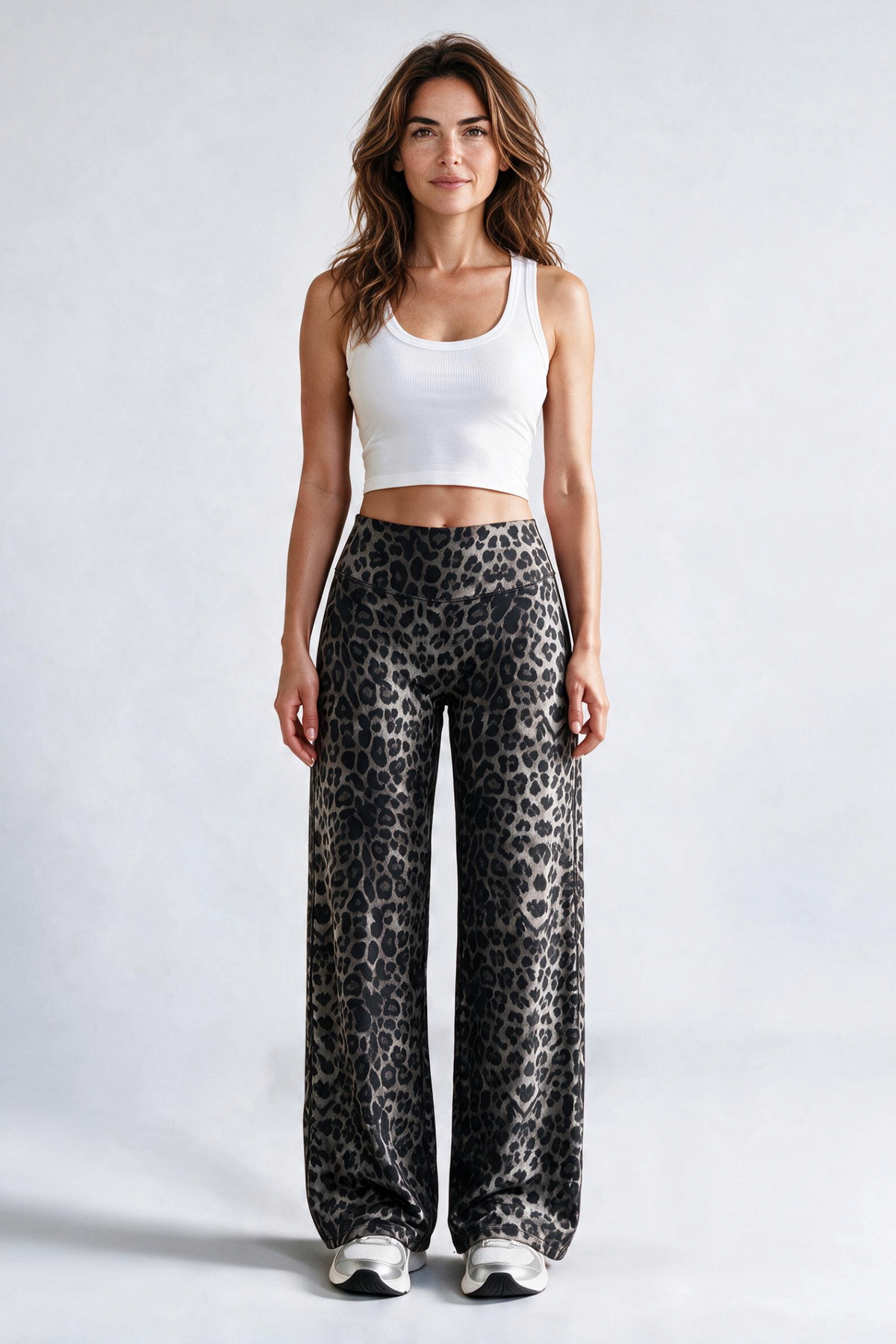 Baya Wear high-waisted wide leg yoga pants in a grey and black leopard print worn by a woman with a white tank top